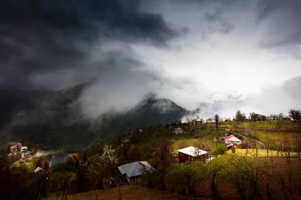Caucasus village and mountains on dark moody day with big clouds — Stock Photo, Image