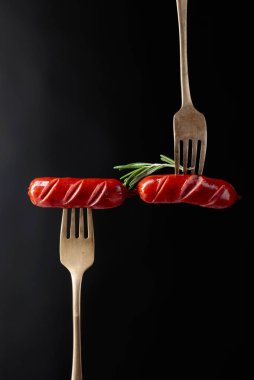 Rosemary bir çatal ile ızgara sosis.