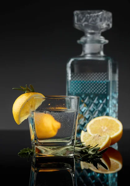 Cocktail gin-tonic avec tranches de citron et brindilles de romarin . — Photo