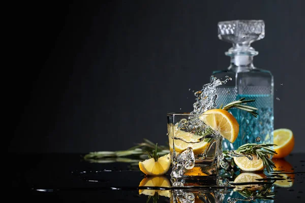 Cocktail gin-tonic avec tranches de citron et brindilles de romarin . — Photo