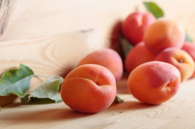 Ahşap bir masa üzerinde yaprakları ile Kayısı.