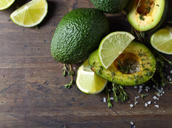 Avocado met limoen op een houten tafel. — Stockfoto