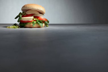 Mozzarella peyniri, domates, salata mutfak masasında ile sandviç.