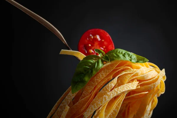 Homemade raw egg noodles with tomato and basil. — Stock Photo, Image