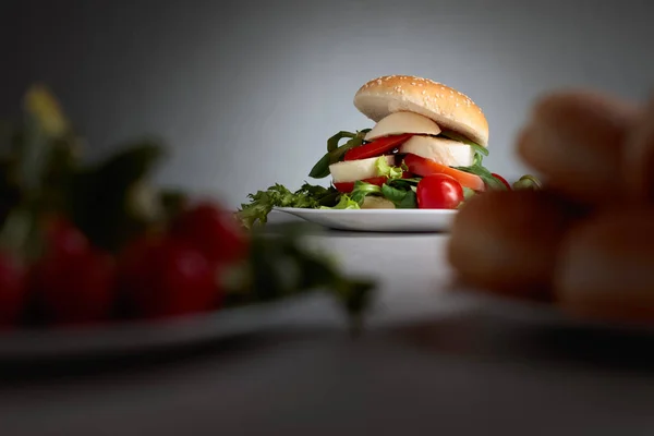 Sandwich con mozzarella, tomate y ensalada en la mesa de la cocina . —  Fotos de Stock