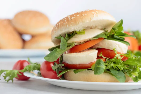 Smörgås med mozzarella, tomat och sallad på köksbordet. — Stockfoto