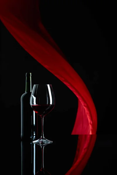 酒杯和一瓶红酒在黑色反光后沟 — 图库照片
