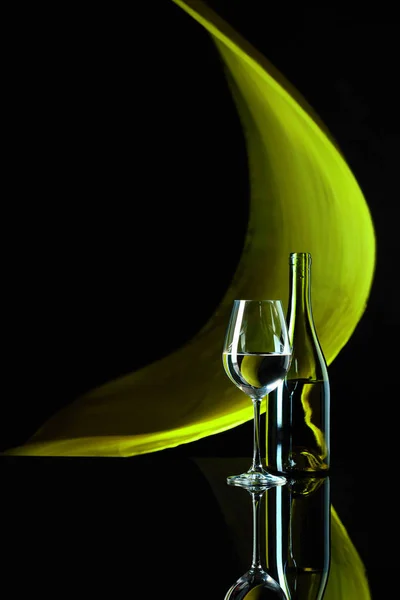 Şarap kadehi ve siyah yansıtıcı backgro beyaz şarap şişesi — Stok fotoğraf