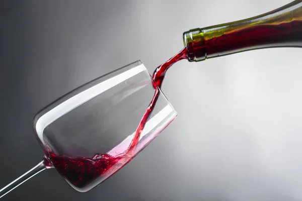 Червоне вино вливають у келих винограду . — стокове фото