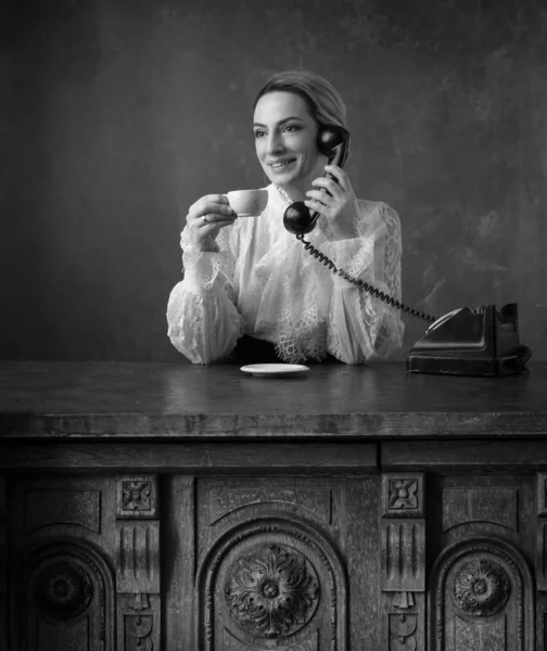 Retrato de una mujer en ropa retro con una taza de café y un — Foto de Stock