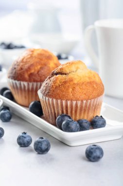 Beyaz masada kekler ve yaban mersini. 