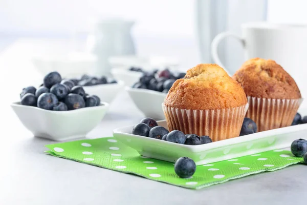 Muffins e mirtilos em uma mesa de cozinha . — Fotografia de Stock