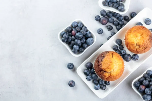 Muffins e mirtilos em uma mesa de cozinha branca . — Fotografia de Stock