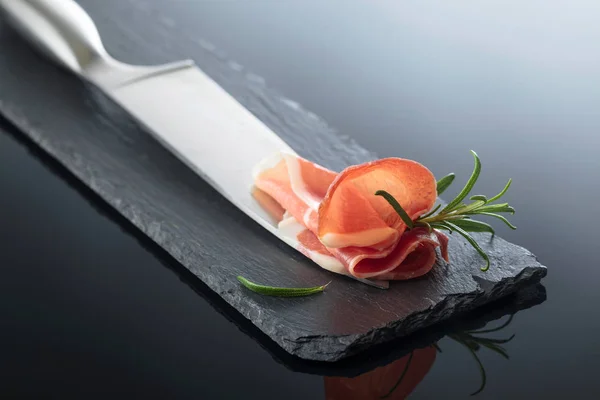 Prosciutto med rosmarin och kökskniv. — Stockfoto