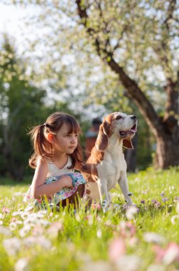 mutlu küçük kız bahçede köpekle oynayan.