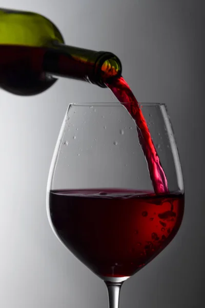 Красное вино наливают из бутылки в бокал. — стоковое фото