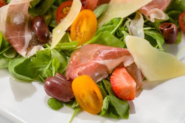 Prosciutto, peynir, domates ve zeytin salatası.