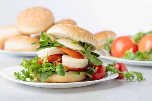 Panino con mozzarella, pomodoro e insalata sul tavolo della cucina . — Foto Stock