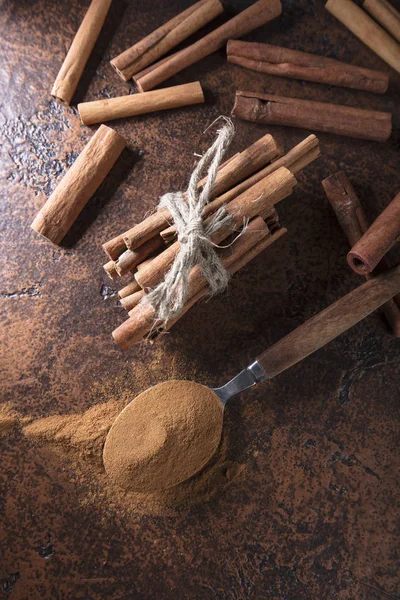 Cinnamon sticks and powder in spoon on a old copper table . — Stock Photo, Image