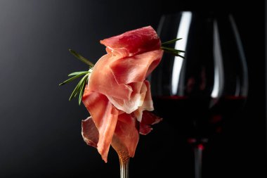 Arka planda kırmızı şarap ve biberiyeli jambon.. 