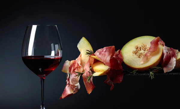 Red wine with prosciutto and melon. — Stock Photo, Image