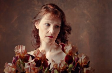 Kahverengi Iris çiçekleri ile çekici kadın.