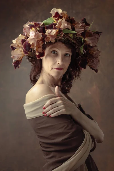 Ελκυστική γυναίκα σε στεφάνι με καστανά άνθη ίριδας. — Φωτογραφία Αρχείου