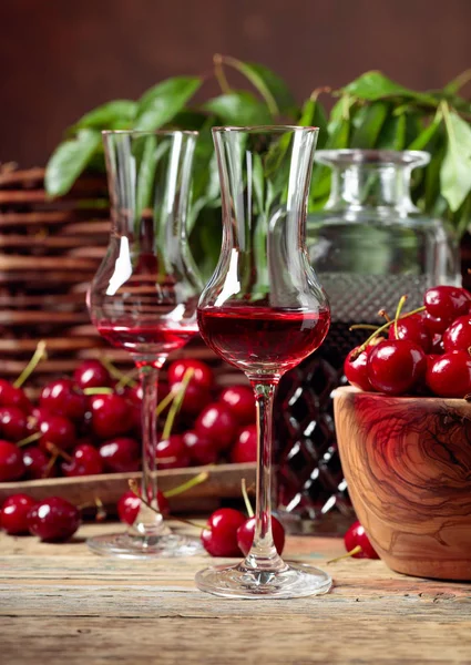 Cherry liquor and red cherries in a wooden bowl on a wooden tabl — Stock Photo, Image