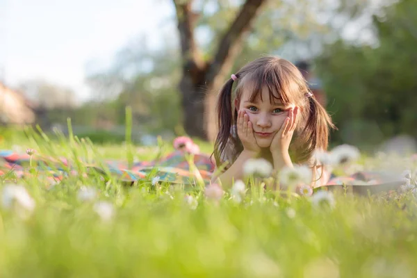 Kleine meid droomt in de tuin. — Stockfoto