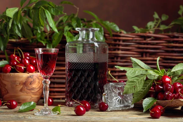 Cherry minuman keras dan ceri merah dalam mangkuk kayu pada tabl kayu — Stok Foto