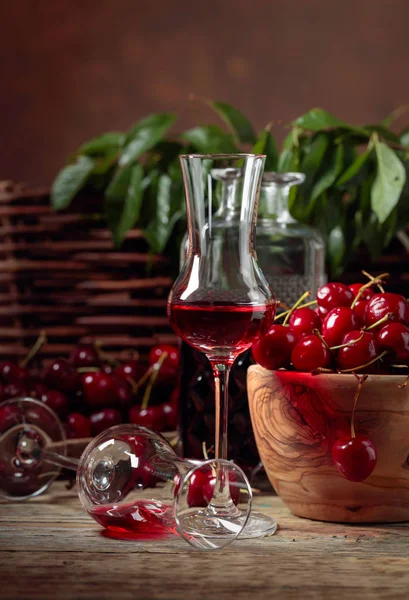 Cherry liquor and red cherries in a wooden bowl on a wooden tabl — Stock Photo, Image