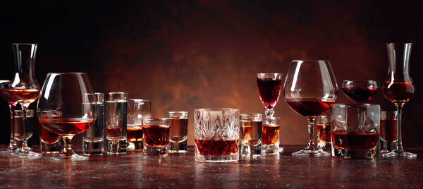Set of strong alcoholic beverages in glasses on a brown backgrou