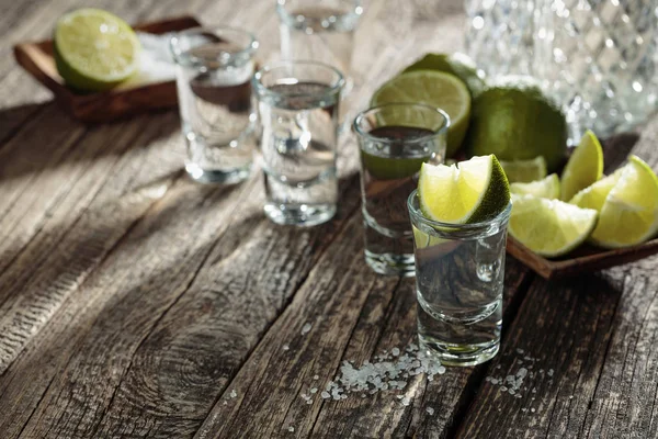 Tequila mit Salz und Kalk auf altem Holzgrund. — Stockfoto