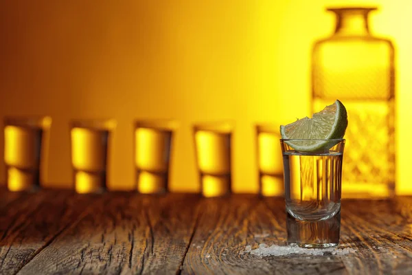 Tequila met zout en limoen op een oude houten achtergrond. — Stockfoto