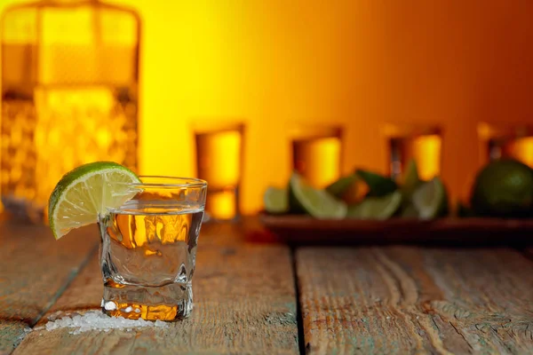 Tequila avec sel et citron vert sur un vieux fond en bois . — Photo