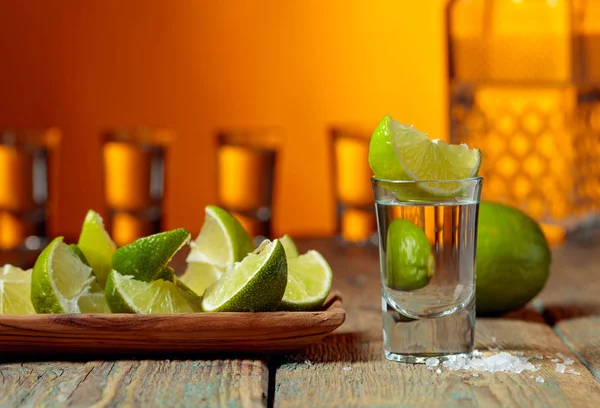 Tequila com sal e limão em um velho fundo de madeira . — Fotografia de Stock
