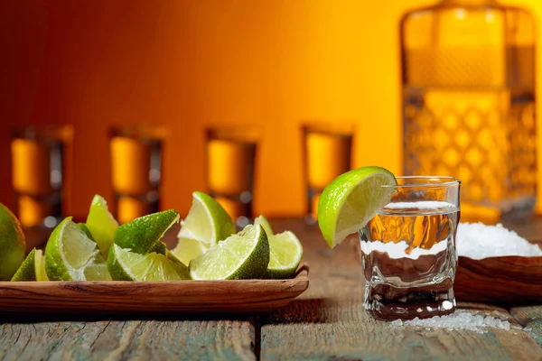Tequila con sal y lima sobre un fondo de madera viejo . — Foto de Stock