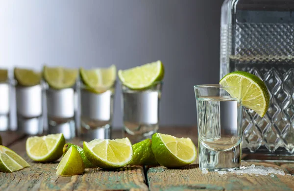 Tequila avec sel et citron vert sur un vieux fond en bois . — Photo