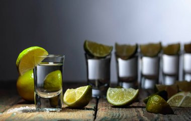 Eski ahşap arka planda tuz ve kireç ile tekila.