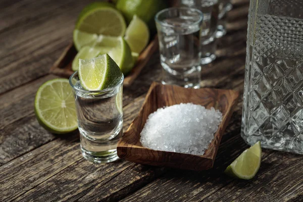 Tequila con sale e calce su un vecchio fondo di legno . — Foto Stock