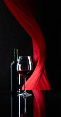 Şarap kadehi ve siyah yansıtıcı backgroun kırmızı şarap şişesi
