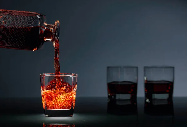 Bevanda alcolica versata da un decanter in un bicchiere . — Foto Stock