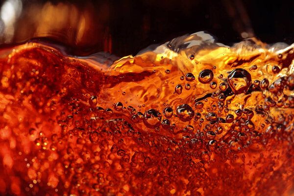 Alcoholic drink on a dark background, abstract splashing.