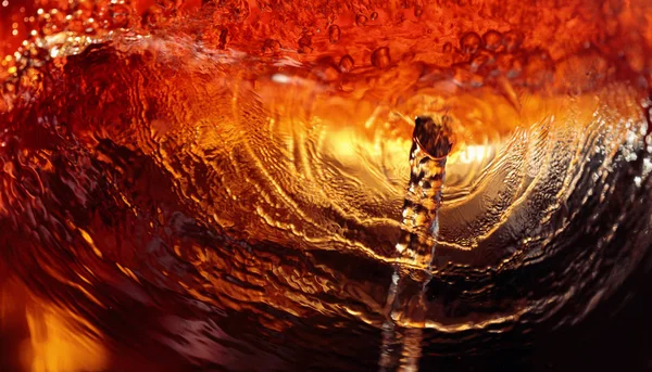 Bebida alcoólica em um fundo escuro, respingos abstratos . — Fotografia de Stock