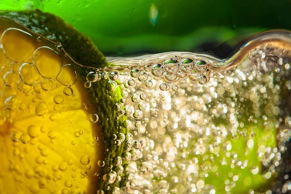 Carbonated drink or cocktail with lime, abstract splashing. — Stock Photo, Image