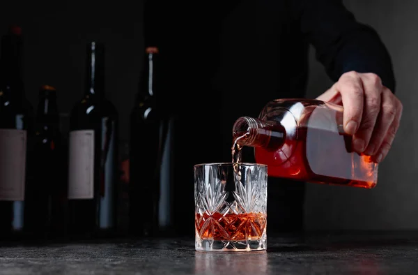 Barman vierte whisky en un vaso en el bar. — Foto de Stock