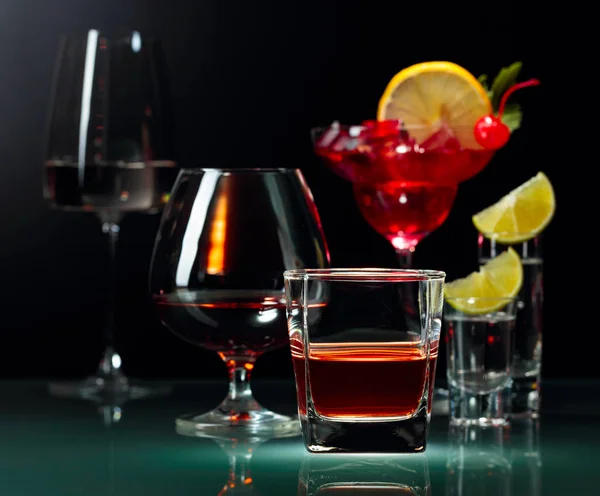 Várias bebidas alcoólicas em um fundo preto . — Fotografia de Stock