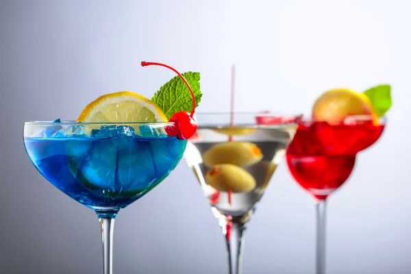 Twee kleurrijke cocktails en droge Martini met groene olijven. — Stockfoto
