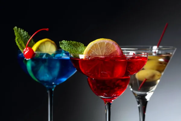 Deux cocktails colorés et martini sec aux olives vertes . — Photo