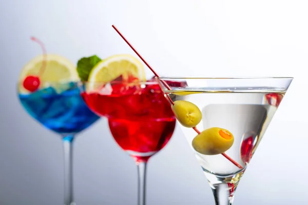 Two colorful cocktails and dry martini with green olives. — Stock Photo, Image